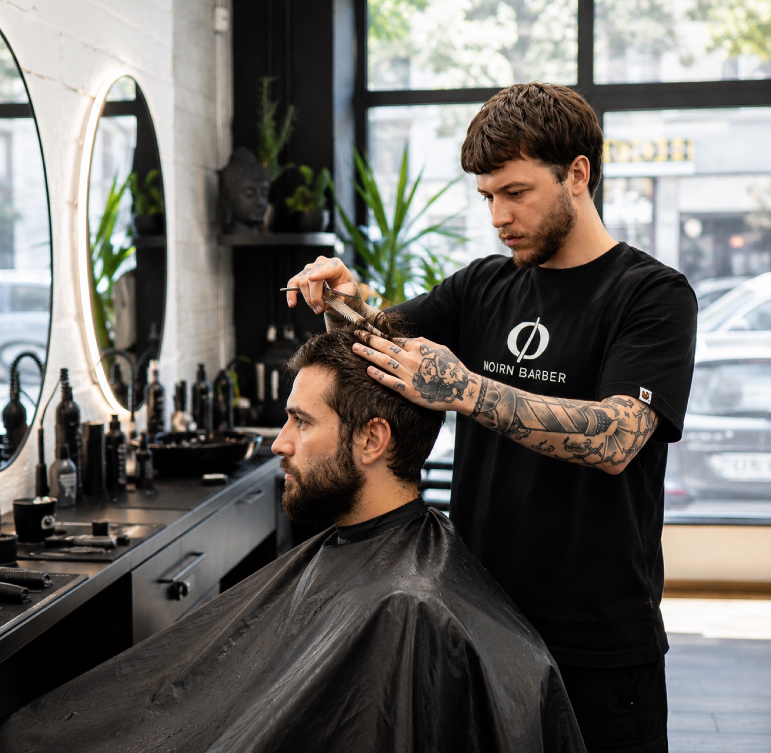 Barber upravuje vlasy klienta pri okne
